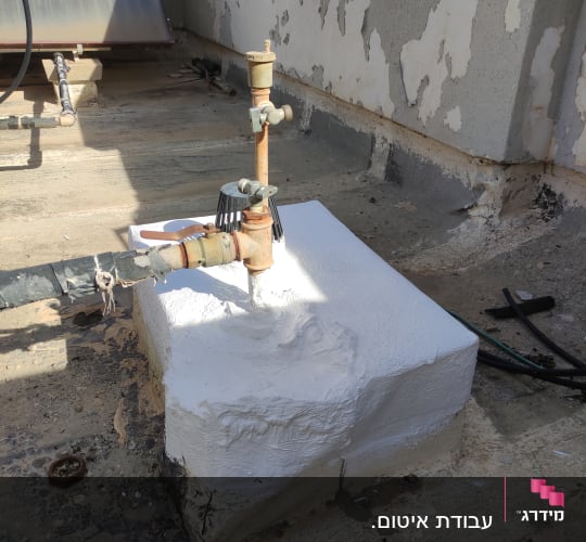 צינור עם איטום לבן על גג בטון